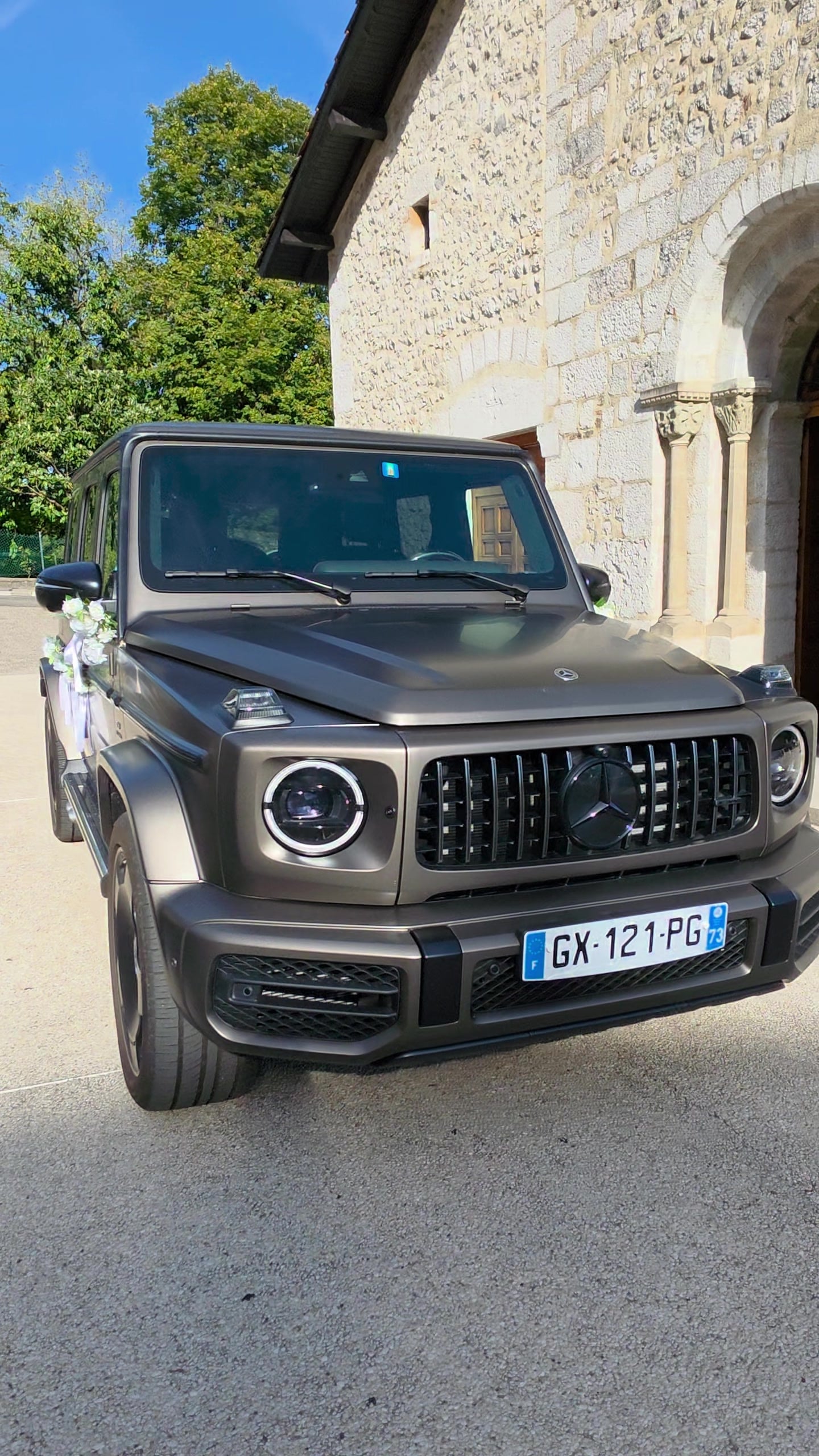 Mercedes Classe G 63 AMG 2025 de face, fleuri, devant l'église