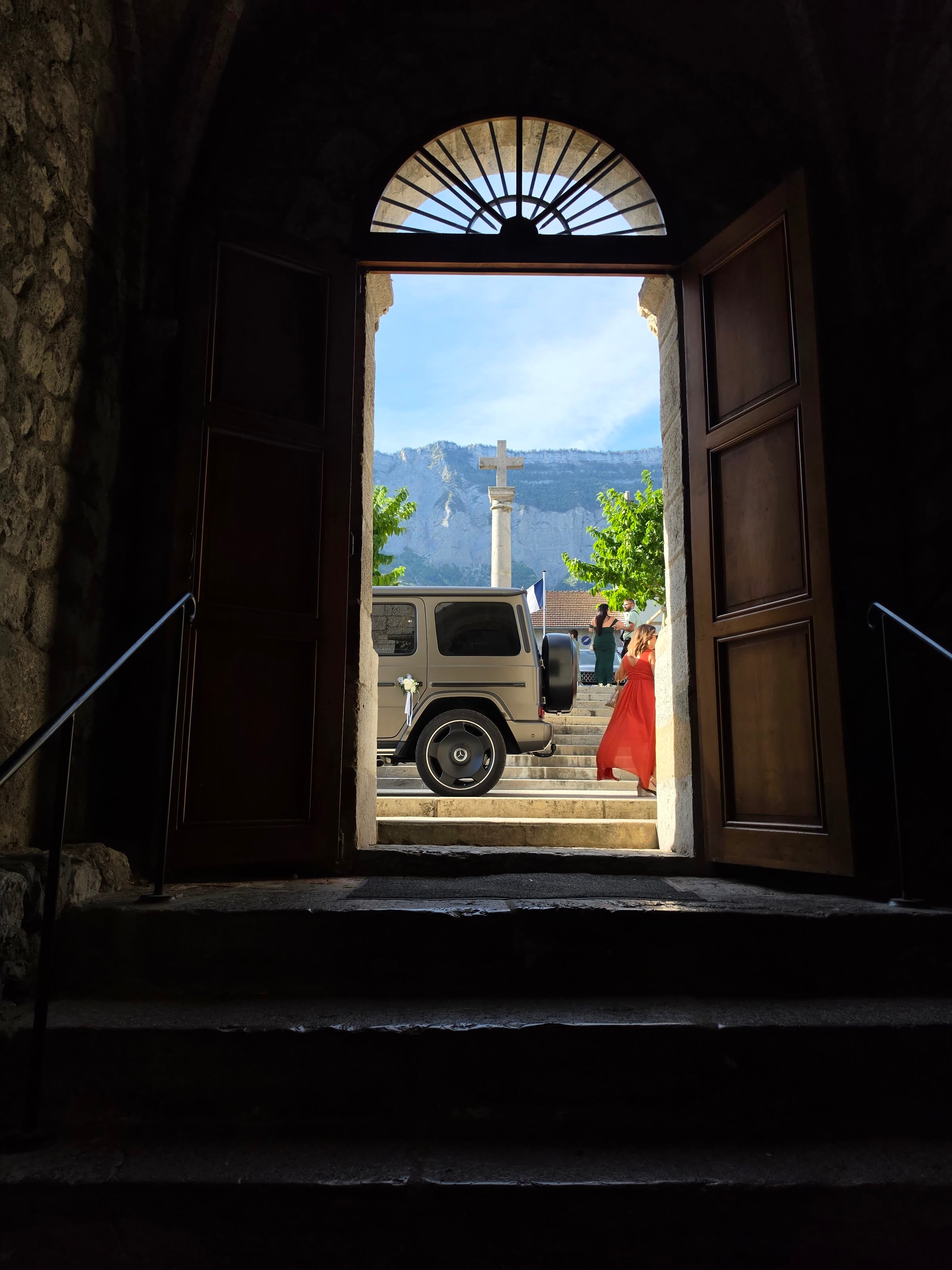 Mercedes Classe G 63 AMG 2025 vu depuis le portail de l'église, montagnes en fond